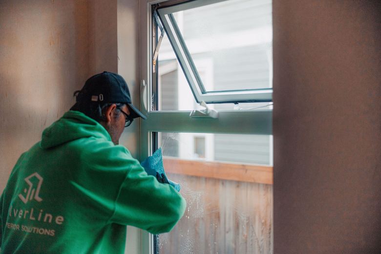 A SilverLine installer in branded workwear adjusting an awning window