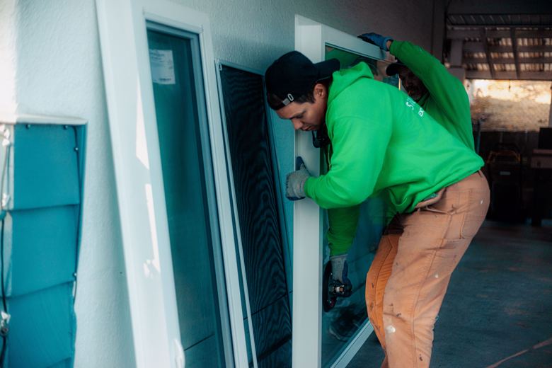 A SilverLine installer carrying a new window frame on site